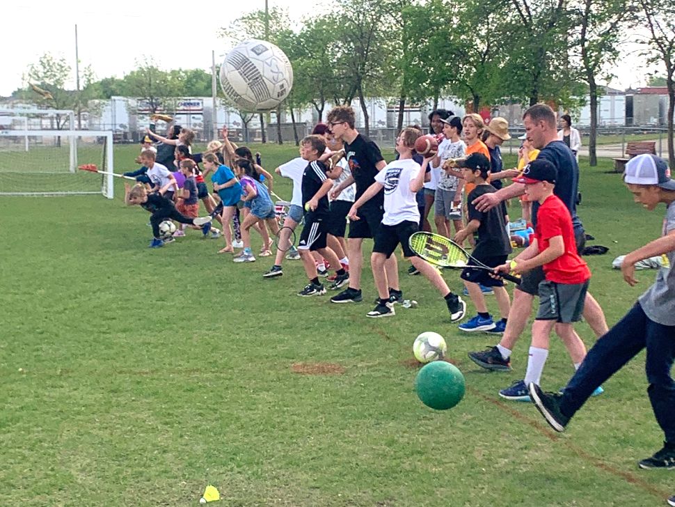 students kick a bunch of sports balls