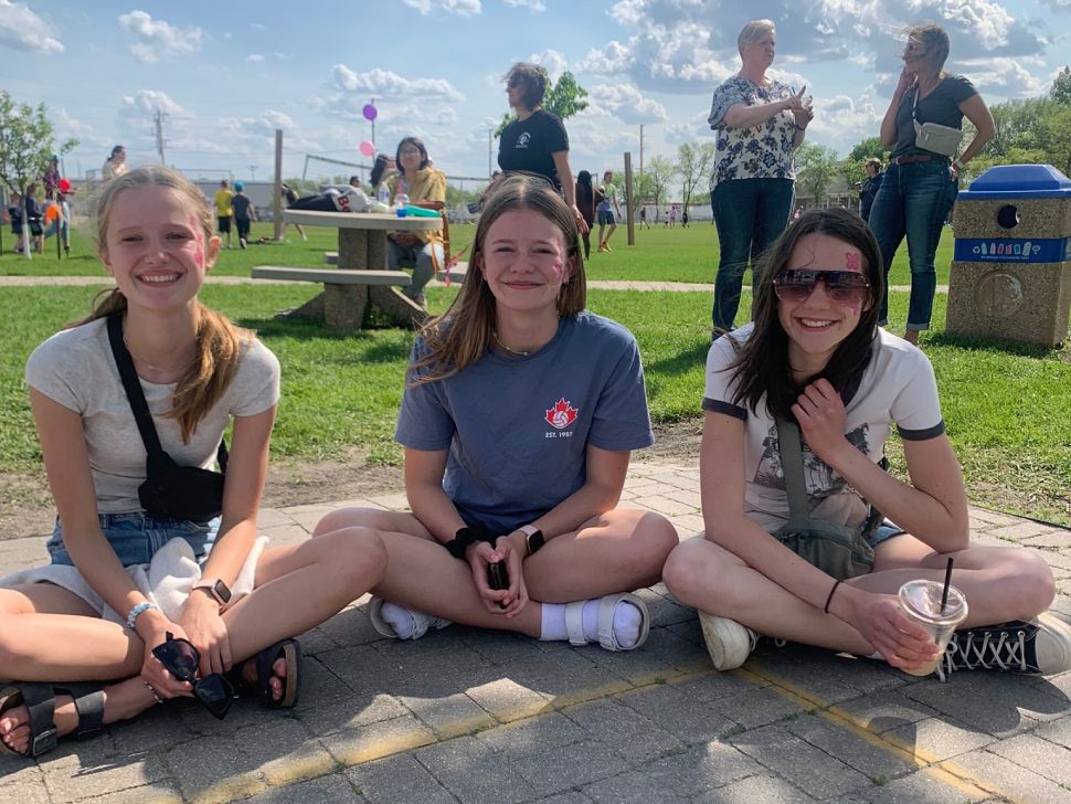 three teenage girls smile at the camera