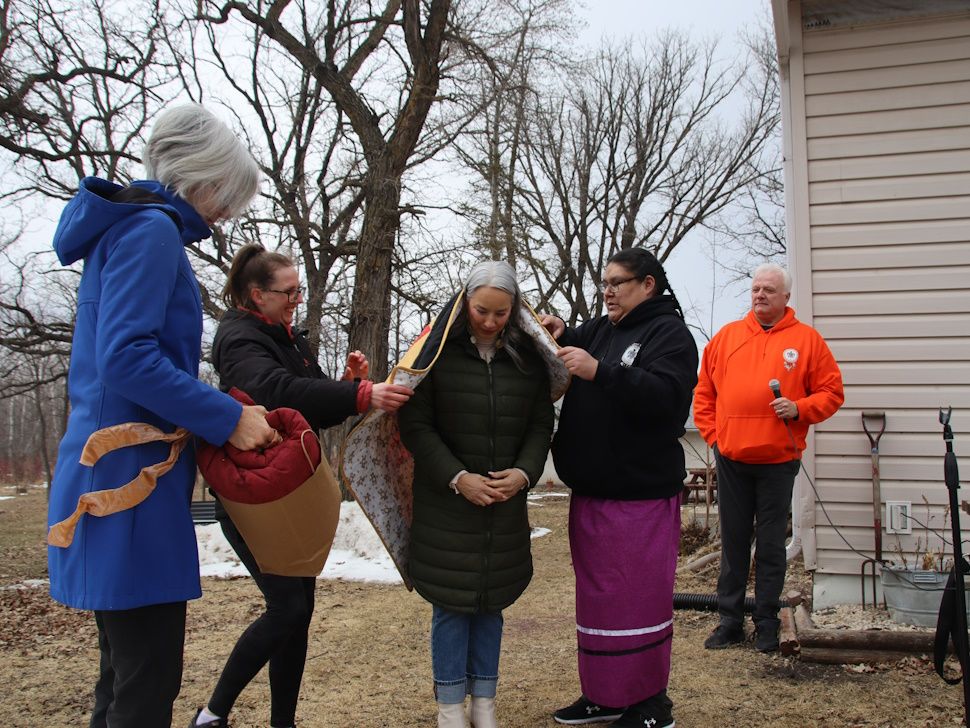 Holly Jonker wraps Star Blanket around the Minister