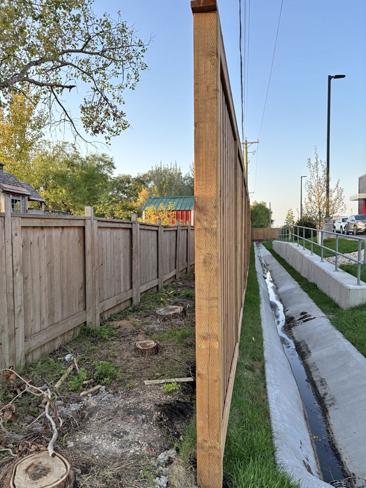 The fence Niverville McDonalds owners built, showing the swale and cut trees next to residential property.
