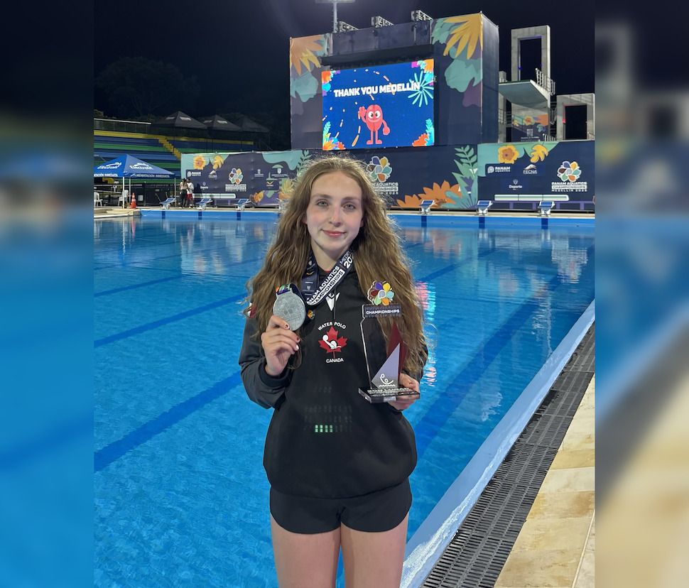 Jennika Linthicum by the pool with medal and award