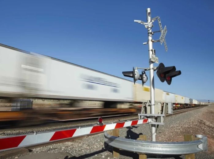 train whizing past a downed railway crossing arm